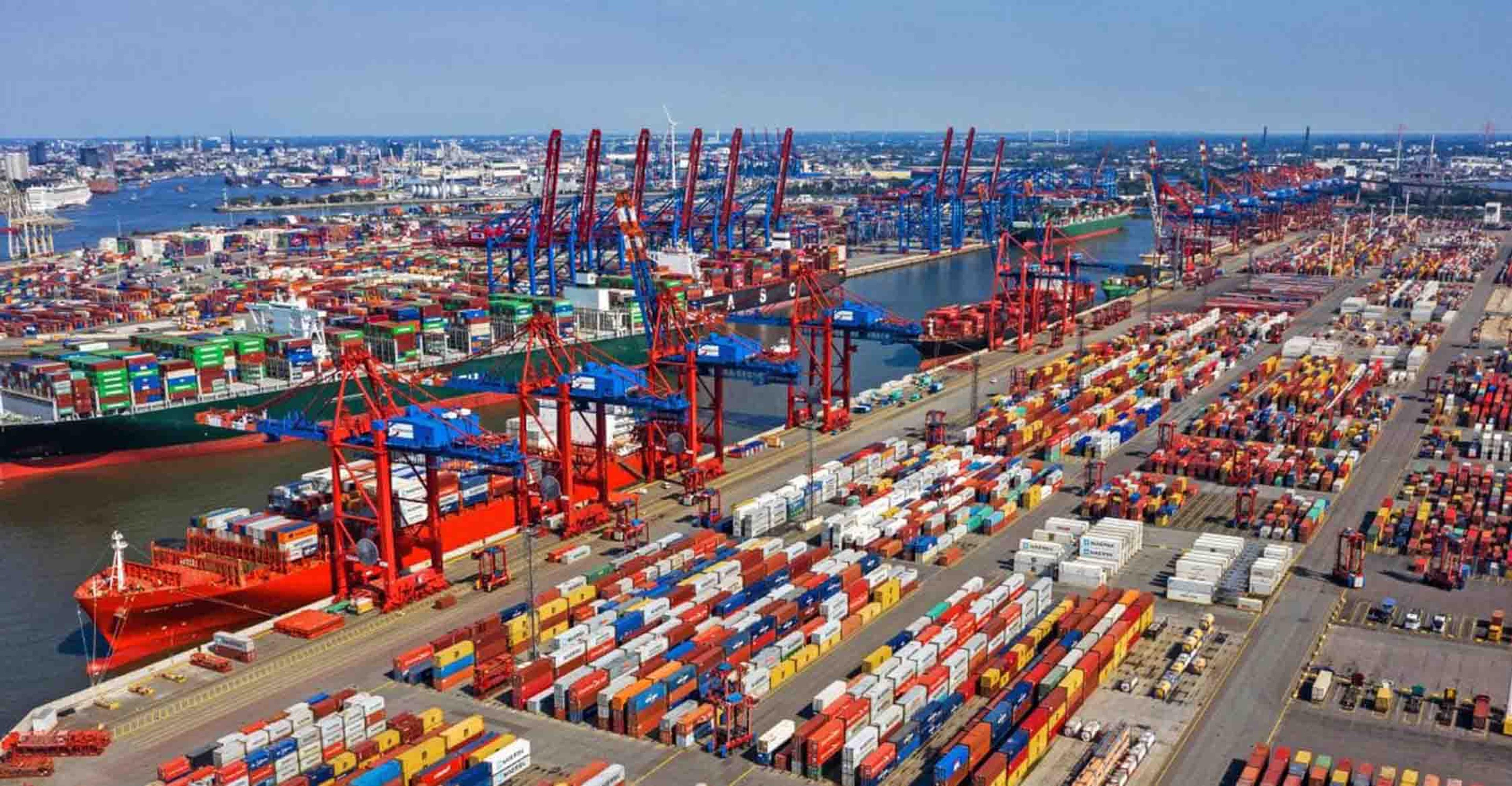 A busy port and a vessel being loaded with containers