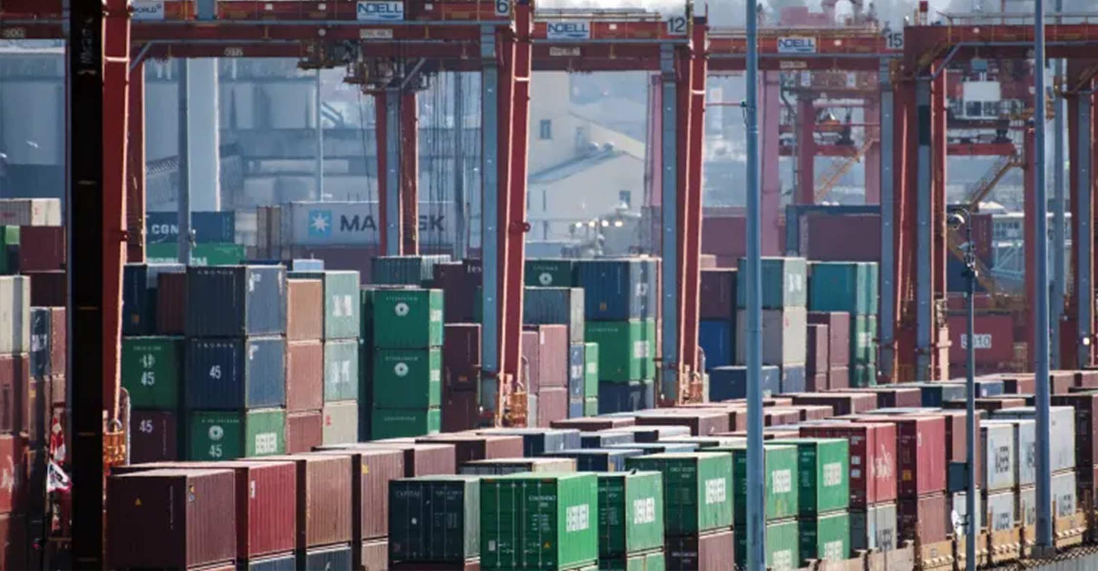 stacks of containers in port and containers loaded onto flat cars