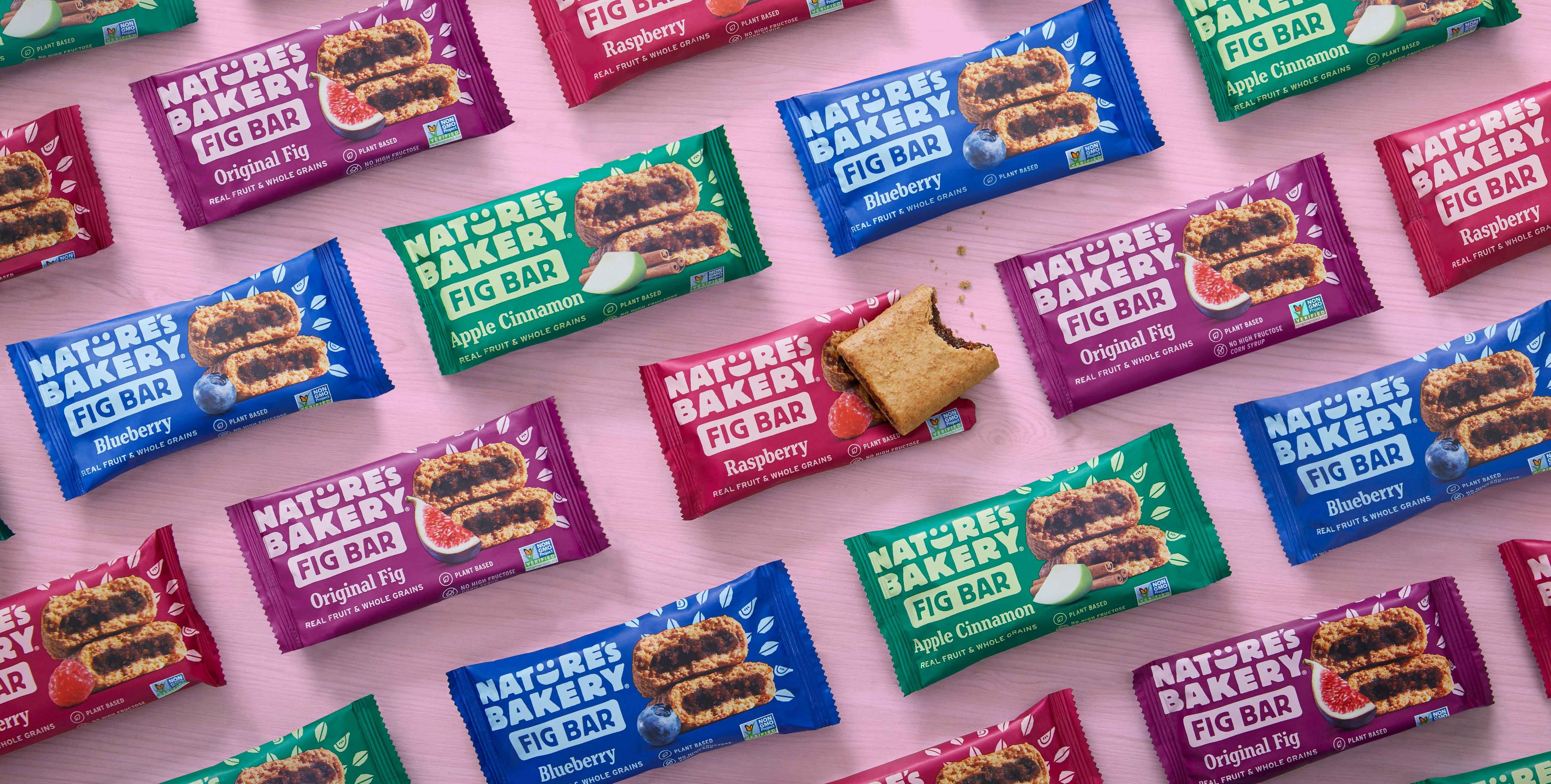 An assortment of Nature's Bakery fig bars on a pink background