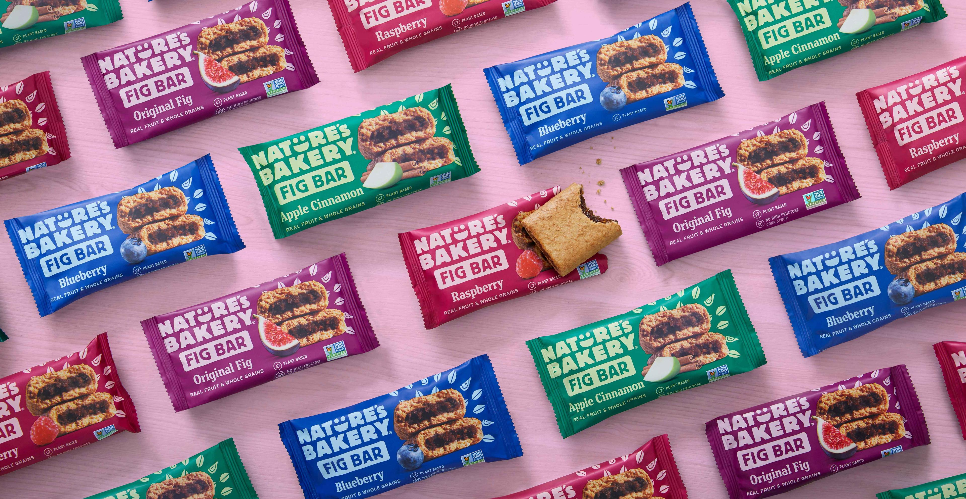 An assortment of Nature's Bakery fig bars on a pink background