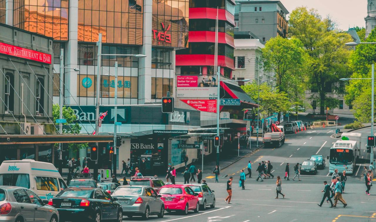 Busy Auckland city centre intersection with cars, a bus and people crossing the road