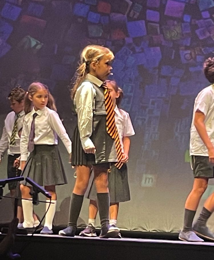 small girl on stage for end of school production