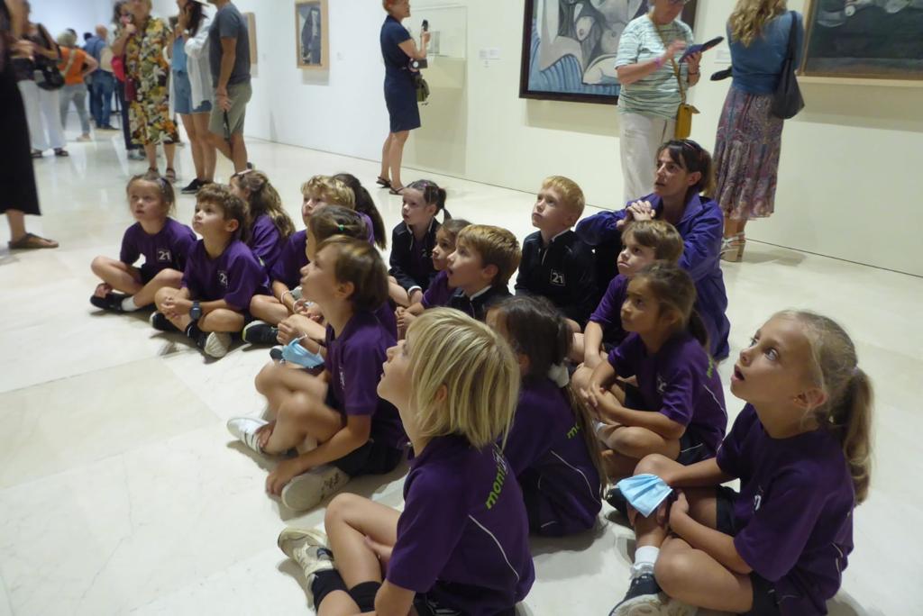 children sitting on floor studying Picasso artwork