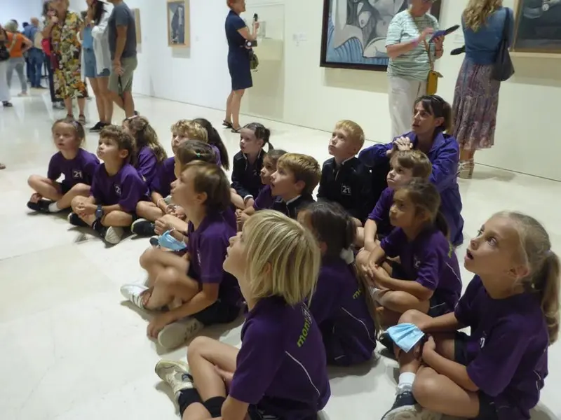 children sitting on floor studying Picasso artwork