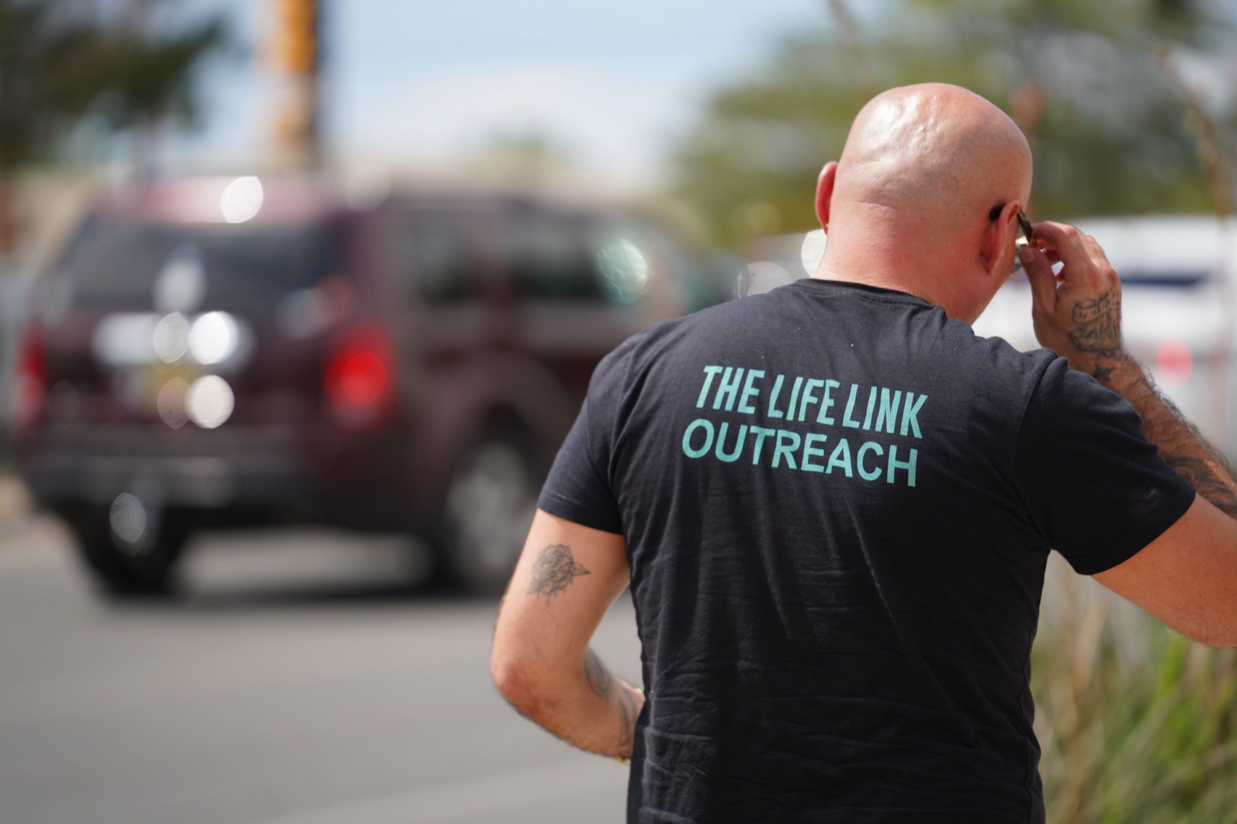 A Life Link outreach worker handing supplies to someone on the street