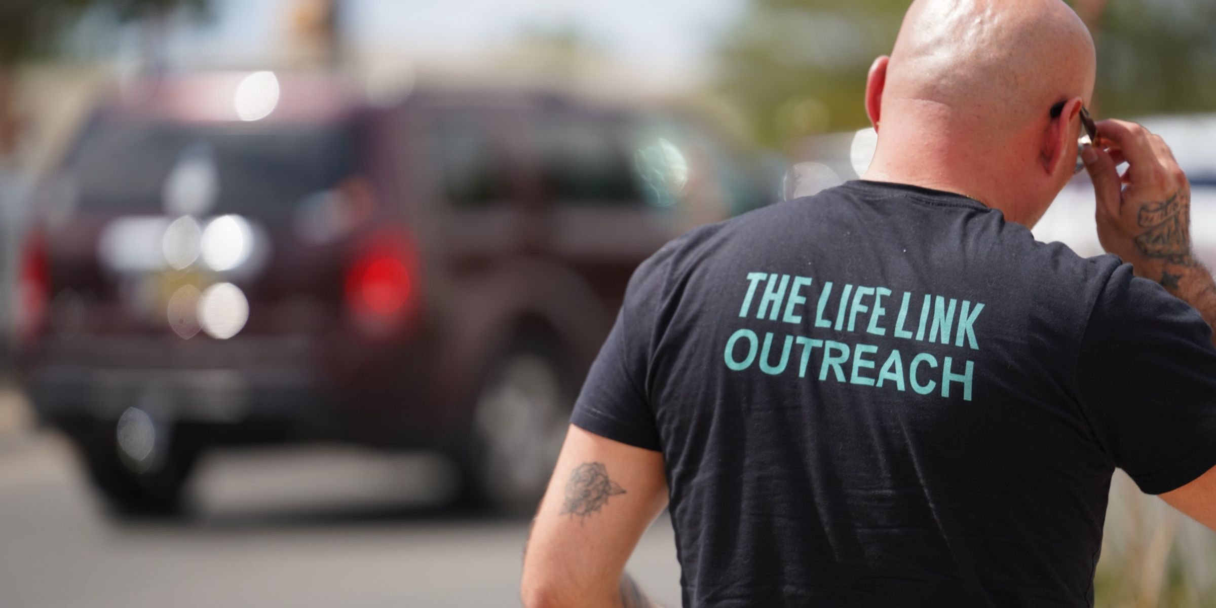 A Life Link outreach worker handing supplies to someone on the street