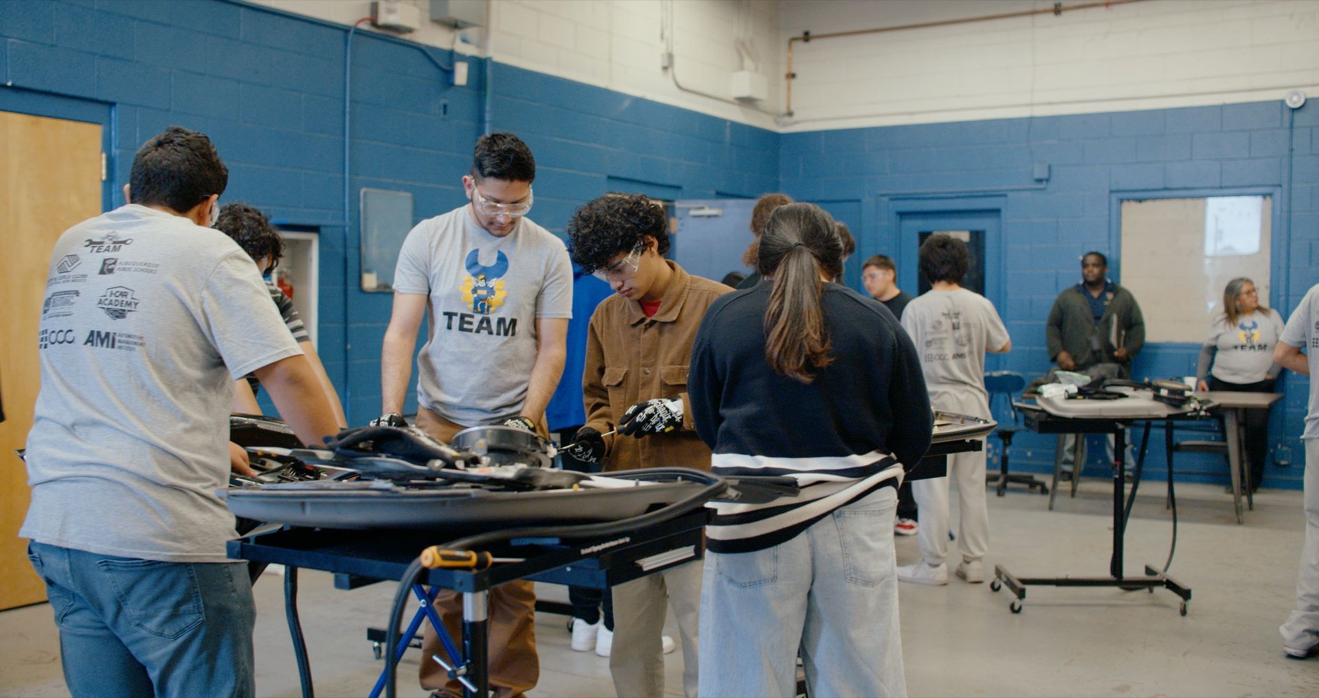 Students working on an automotive engine as part of an I-CAR Academy technical education program