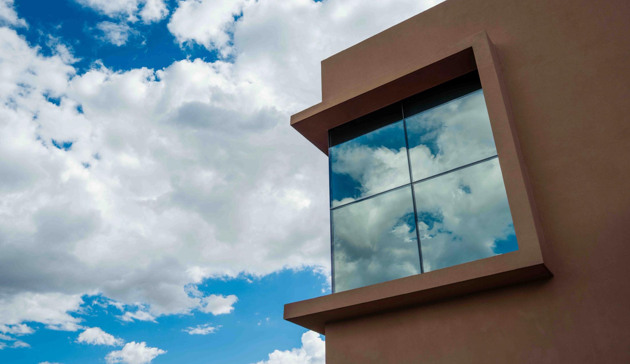 The Thornburg Foundation building against a partly cloudy sky, with sunlight reflecting off a window