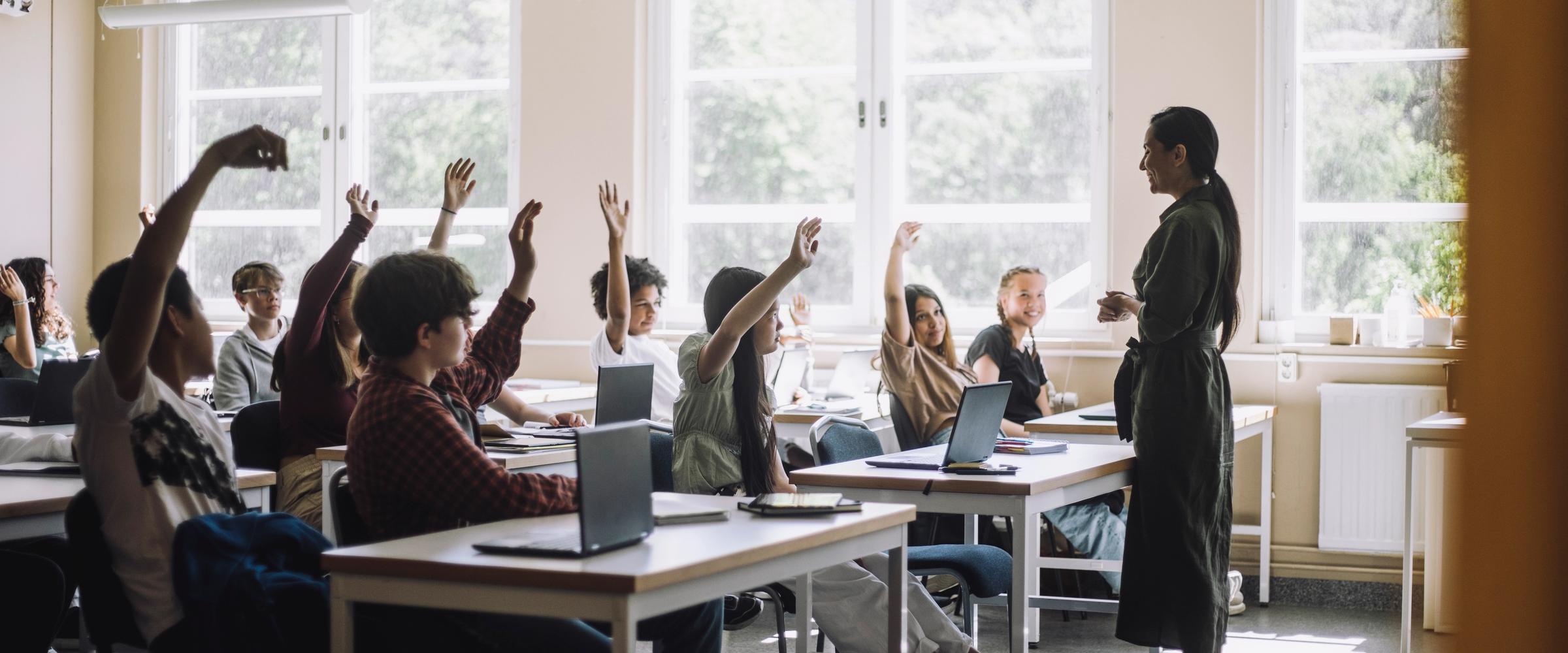 Students raising their hands during a lesson