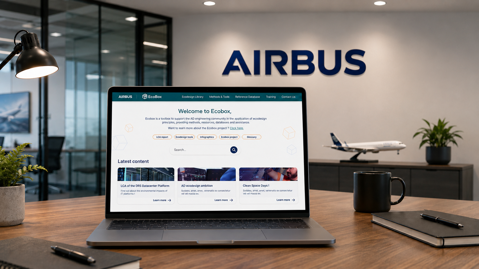 Mockup de la plateforme ECOBOX d’Airbus affichée sur un ordinateur portable dans un environnement de bureau.