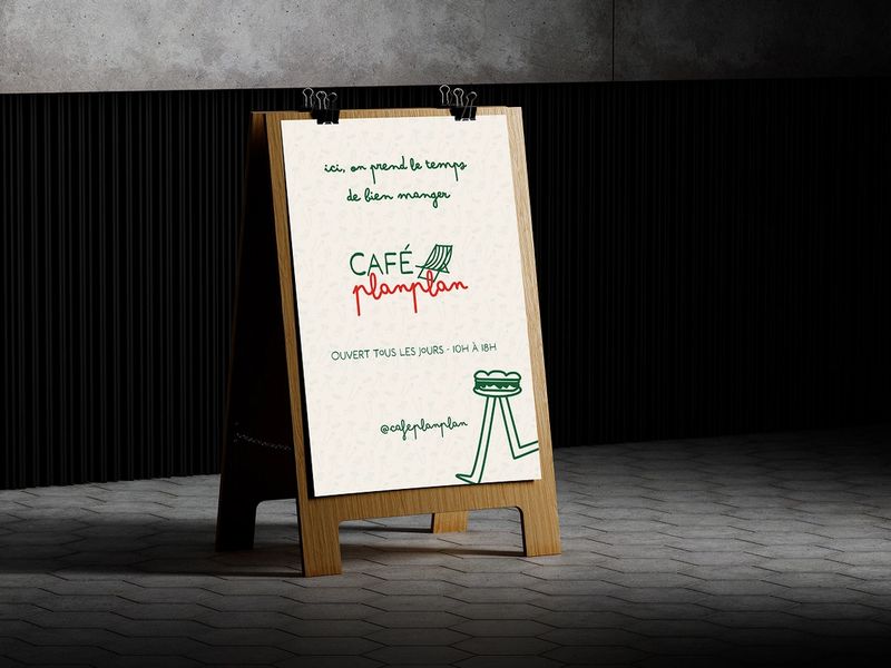 Chevalet en bois installé devant le Café Planplan, présentant son identité visuelle dessinée à la main et ses horaires d’ouverture.
