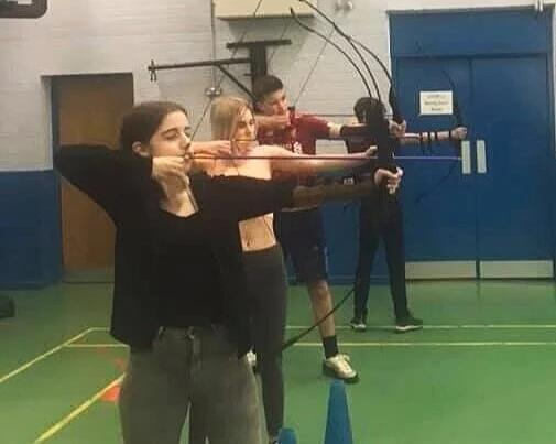 Young people trying archery