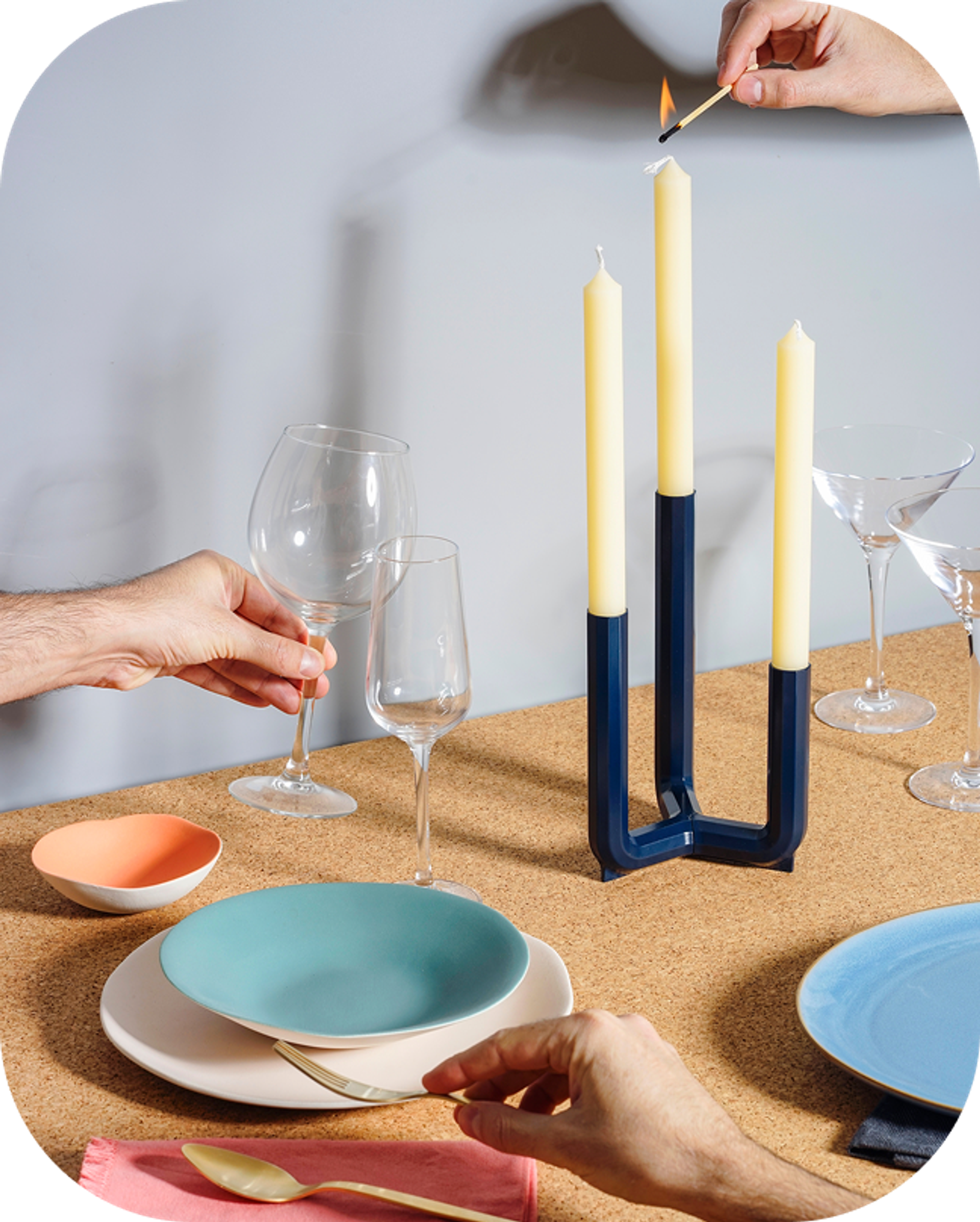 Dinner table with plates, candle and people cheer
