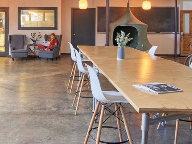 Main coworking floor with long table and lounge area at The Studio Boulder, Boulder, CO