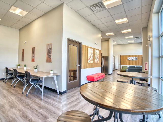 Open coworking area with shared desks and cafe tables at Leaf Coworking, Firestone, CO