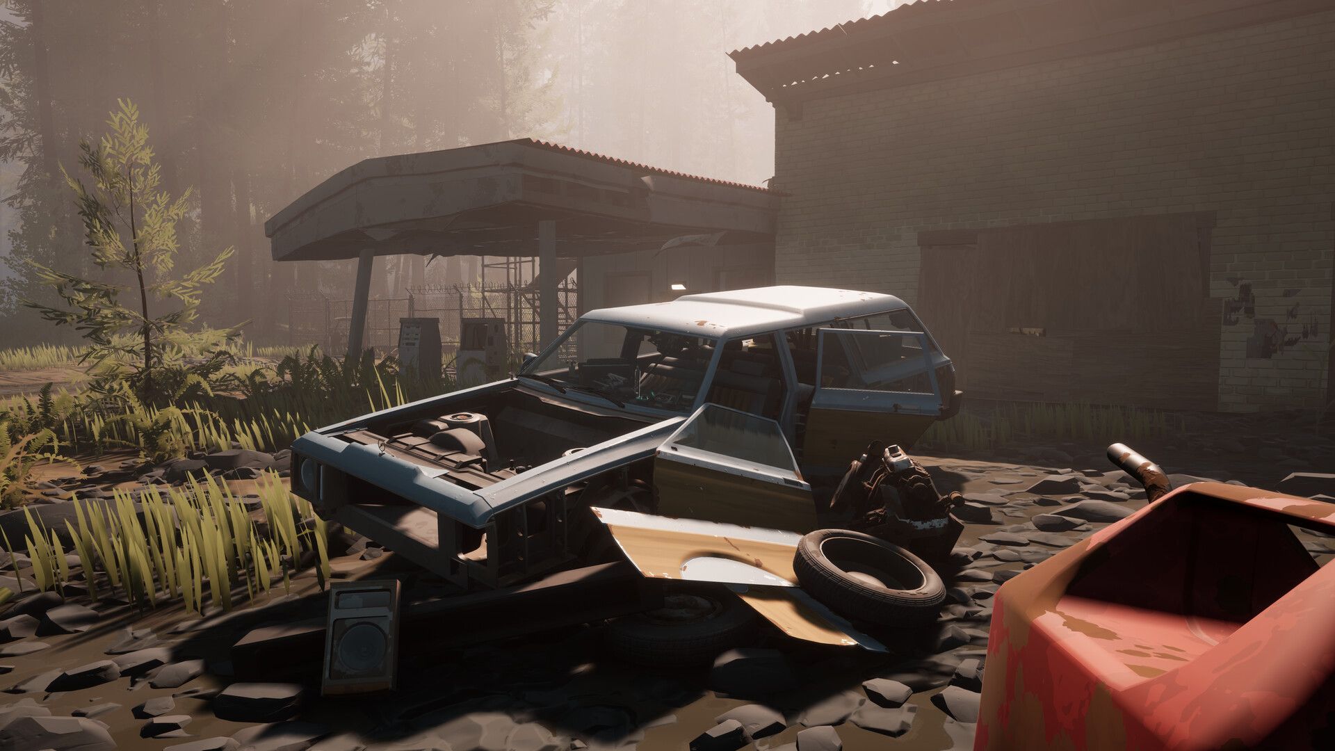 A dismantled station wagon beside an abandoned garage