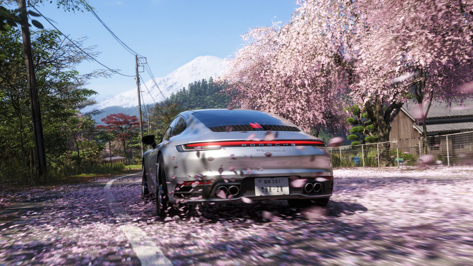 A silver Porsche drives beneath cherry blossoms with Mount Fuji behind it in Forza Horizon 6.