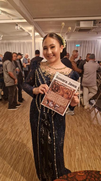 Jonge vrouw in kebaya met de eerste editie, tijdens een avondprogramma