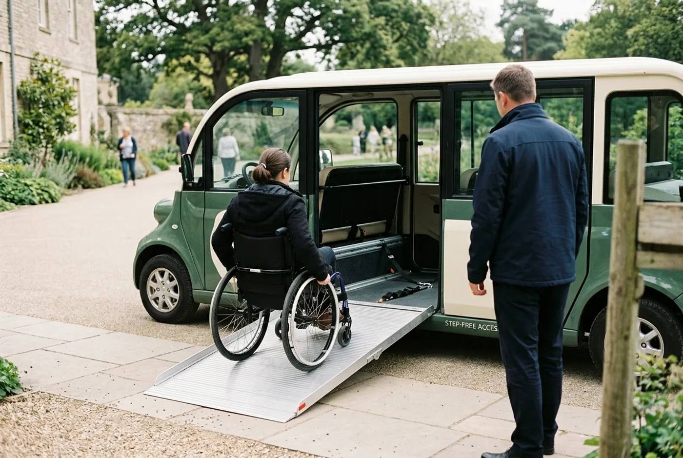 A wheelchair user boarding an electric buggy via a gentle ramp at a step-free venue entrance, calm and unhurried