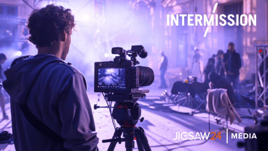 Camera operator on a hazy film set, with Intermission and Jigsaw24 Media logos