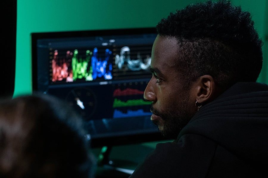 Colorist reviewing video scopes on a monitor in a grading suite