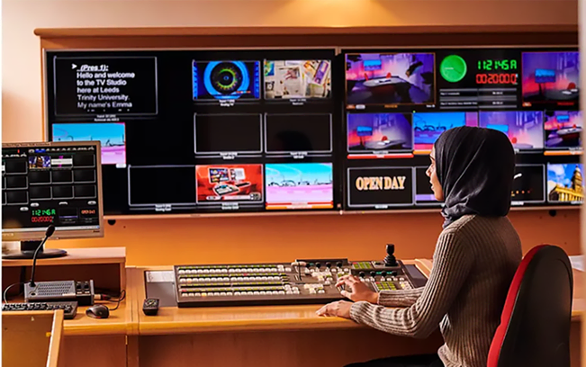 Student operating a vision mixer in the Leeds Trinity University TV studio gallery
