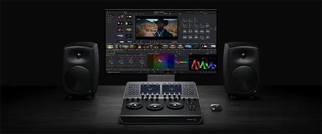 DaVinci Resolve 20 color page on a monitor with a Blackmagic grading control panel and studio speakers