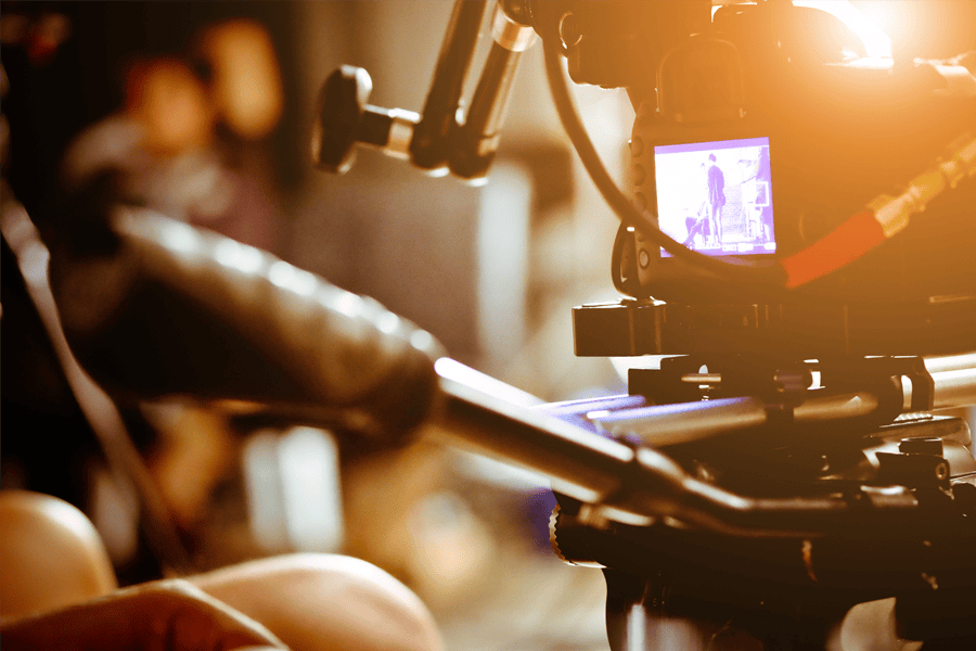 Close-up of a cinema camera rig with its monitor showing the scene on a film set