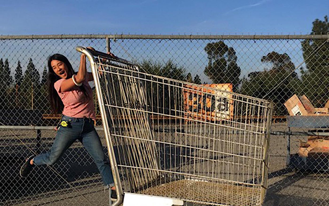 Ester Kim playfully pushing a shopping cart at the Universal Studios prop house