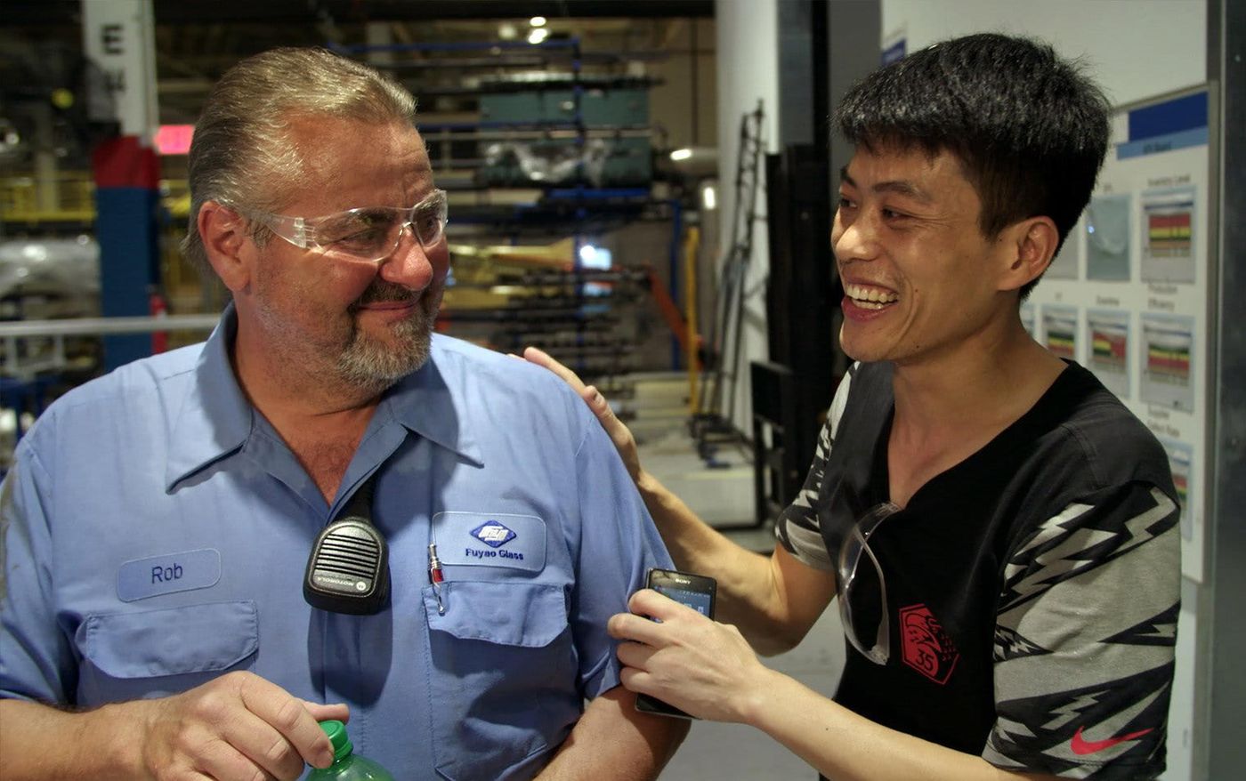 Rob Haerr and Wong He sharing a laugh on the factory floor in American Factory (credit: Ian Cook)