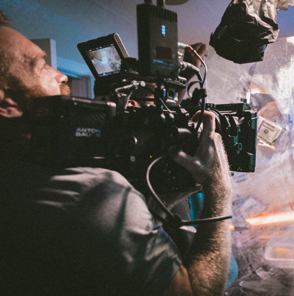 Camera operator filming with a rigged cinema camera and on-camera monitor