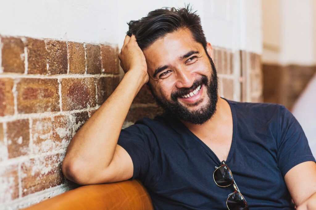 Chello co-founder and creative director Tristan Velasco smiling against a brick wall