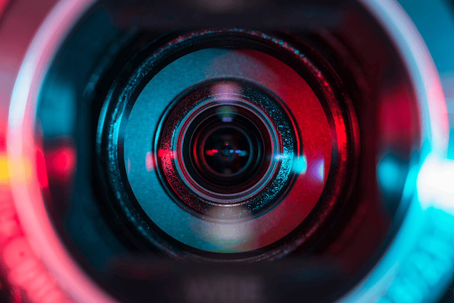 Close-up of a camera lens lit in red and blue