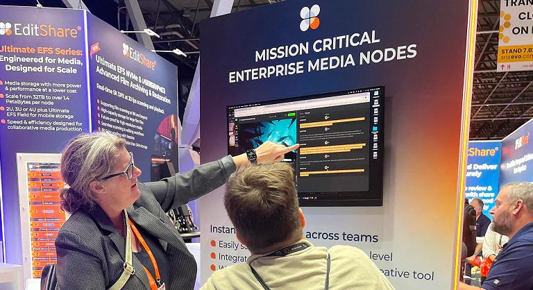 EditShare staff member demonstrating FLOW on a screen to a visitor at the EditShare stand at IBC 2025