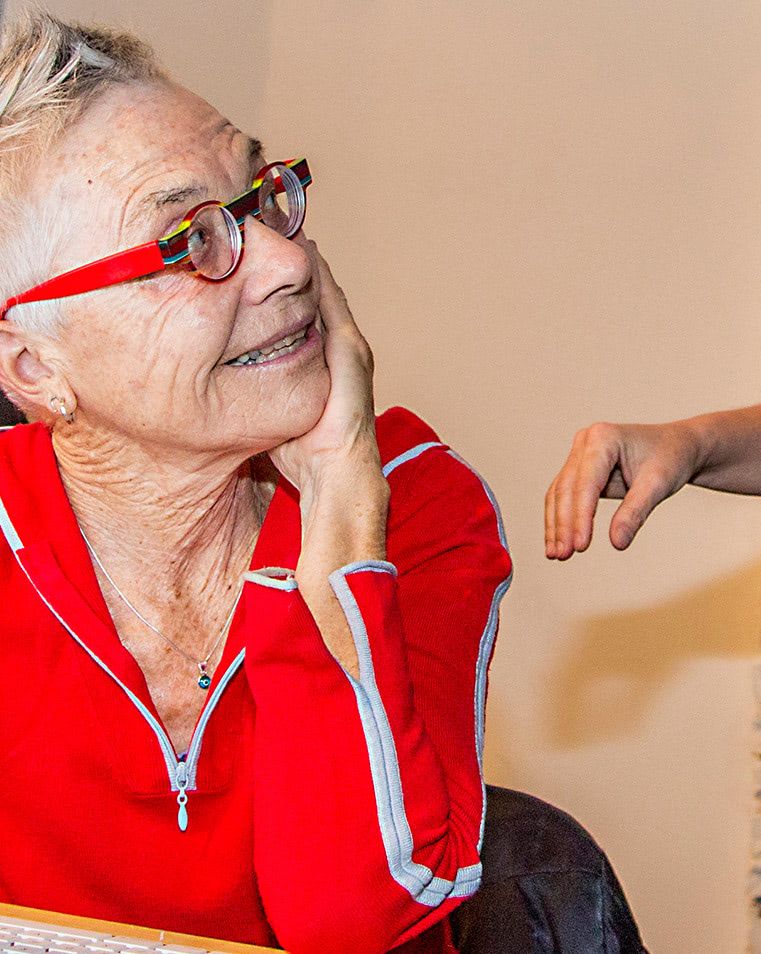 Filmmaker Barbara Hammer in red glasses smiling during a conversation