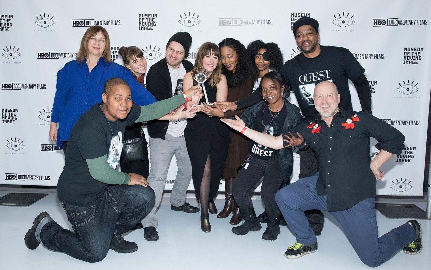 Lindsay Utz, center, holding her Cinema Eye prize surrounded by the Quest cast and crew