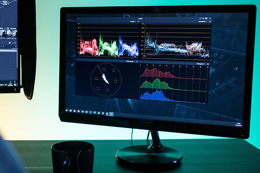 Monitor displaying color grading scopes: parade, waveform, vectorscope, and histogram