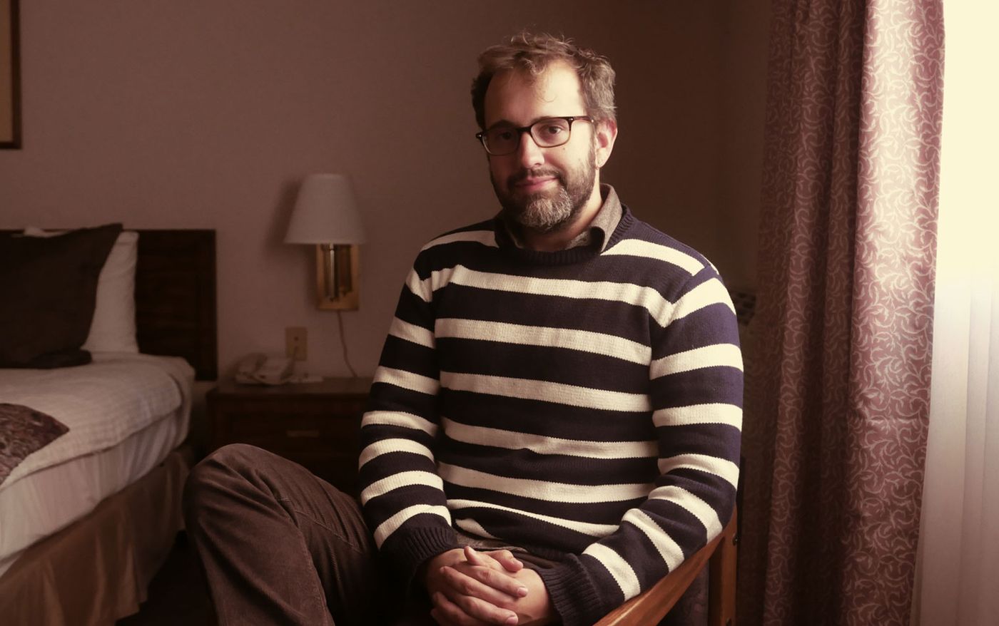 Editor and director Eric Kissack seated in a hotel room