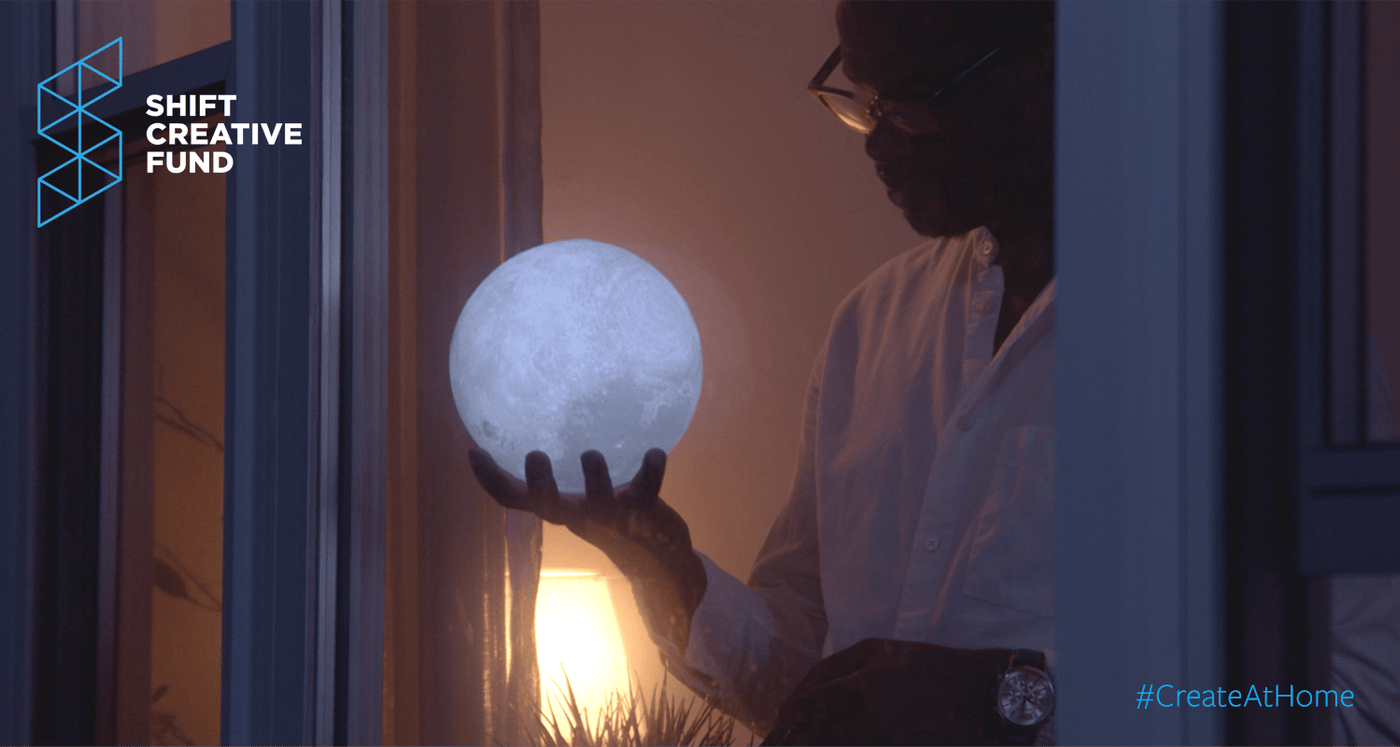 Shift Creative Fund #CreateAtHome still: a man holds a glowing moon lamp at a window