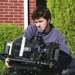 Ian Dumas, MassArt film student, operating a film camera outdoors