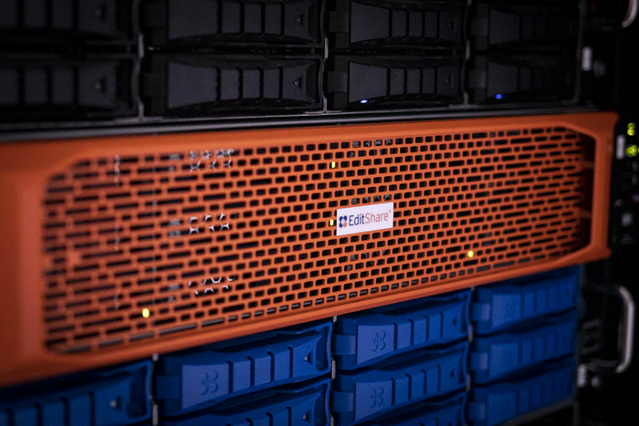 Close-up of an orange EditShare storage node between drive enclosures in a server rack