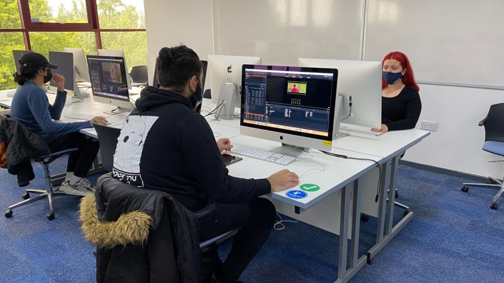 University of Hertfordshire students editing video on iMacs in a campus lab