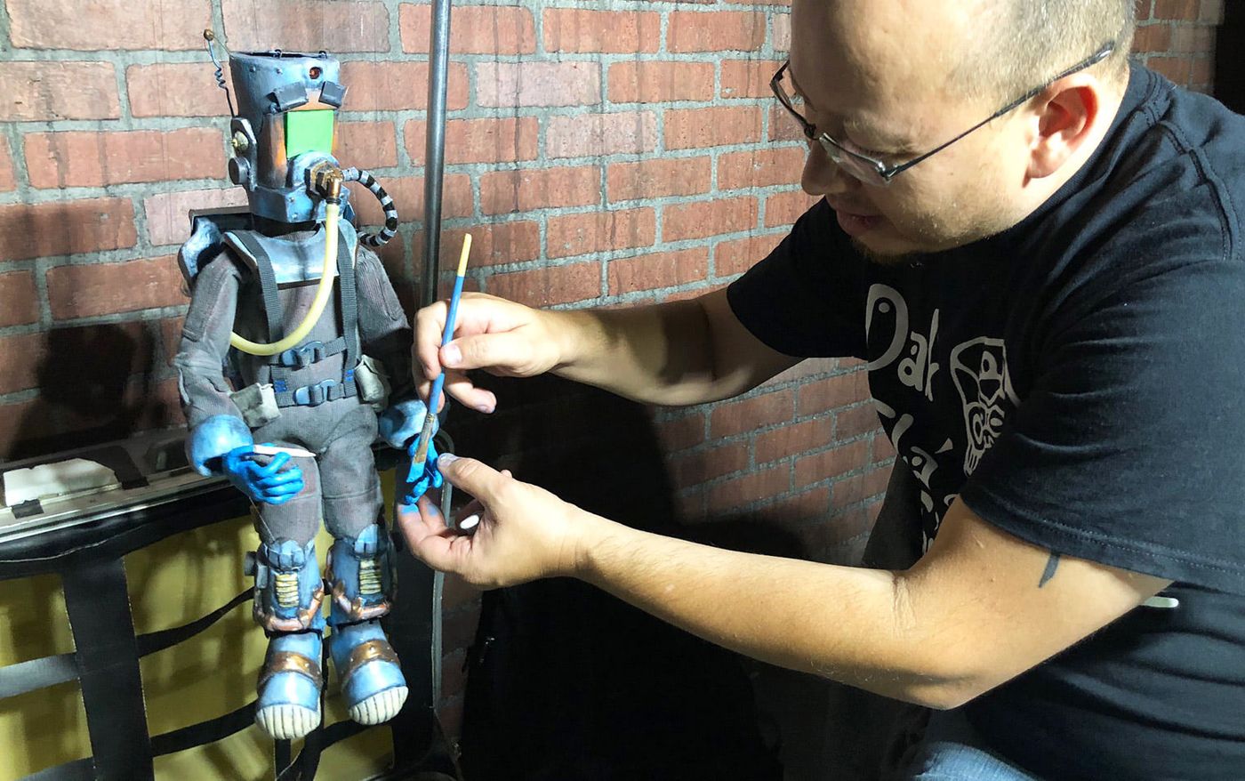 Producer Sam Hale painting Stan, the marionette protagonist of Cosmic Fling