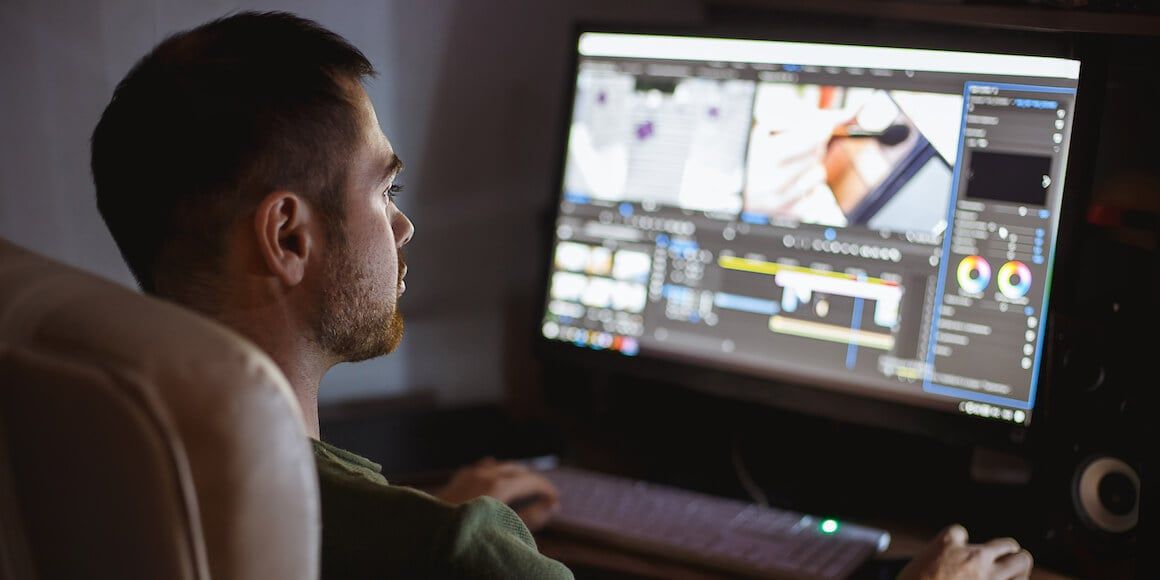 Man on Computer editing audio and video.