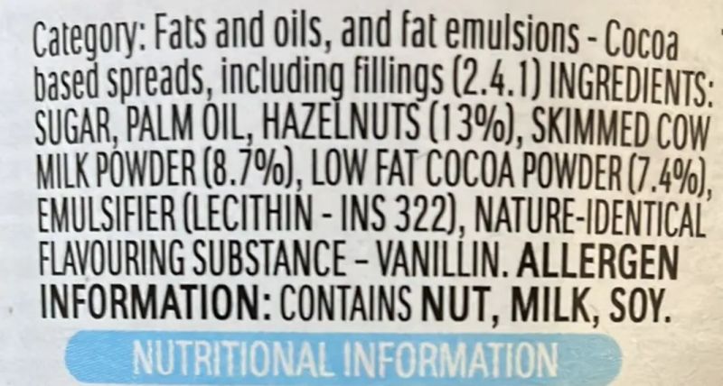 The image displays the nutritional information and ingredients of a cocoa-based spread. The ingredients include sugar, palm oil, hazelnuts (13%), skimmed cow milk powder (8.7%), low-fat cocoa powder (7.4%), emulsifier (lecithin - INS 322), and a nature-identical flavoring substance, vanillin. The allergen information indicates that the product contains nuts, milk, and soy.
