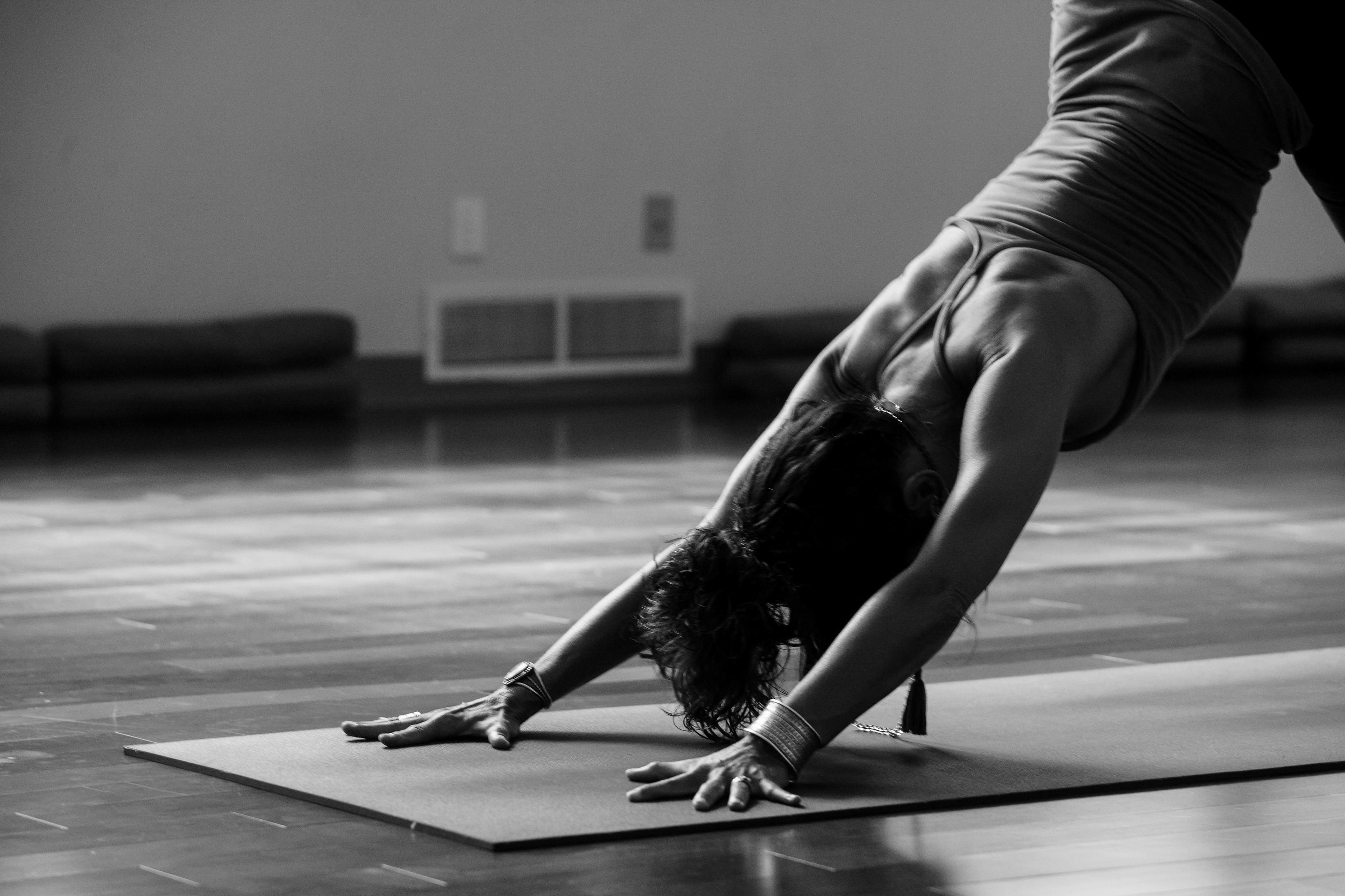 Eine Person führt die Yoga-Position Herabschauender Hund auf einer Yogamatte aus