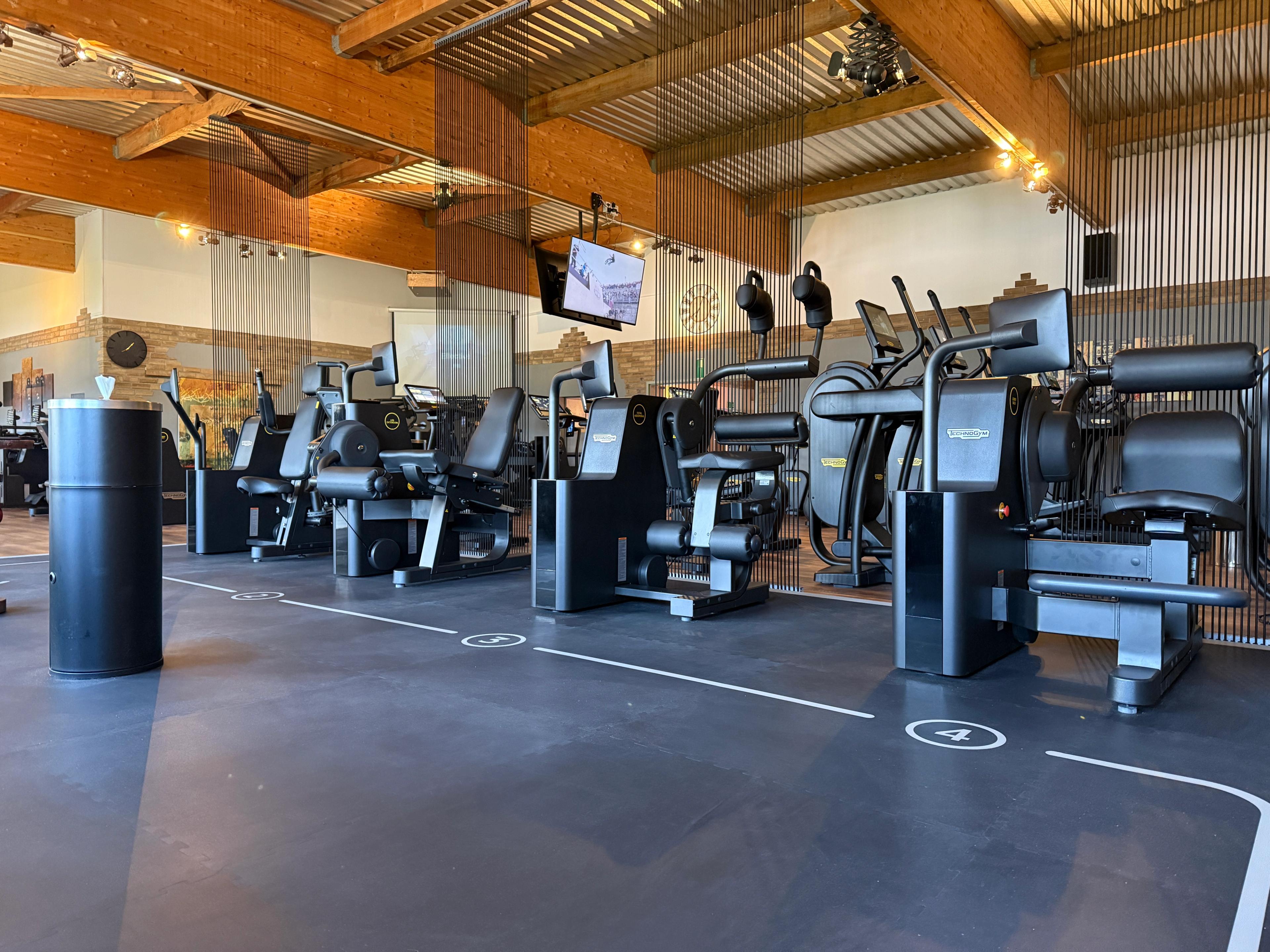 Ein geräumiges Fitnessstudio mit mehreren Laufbändern und modernen Geräten