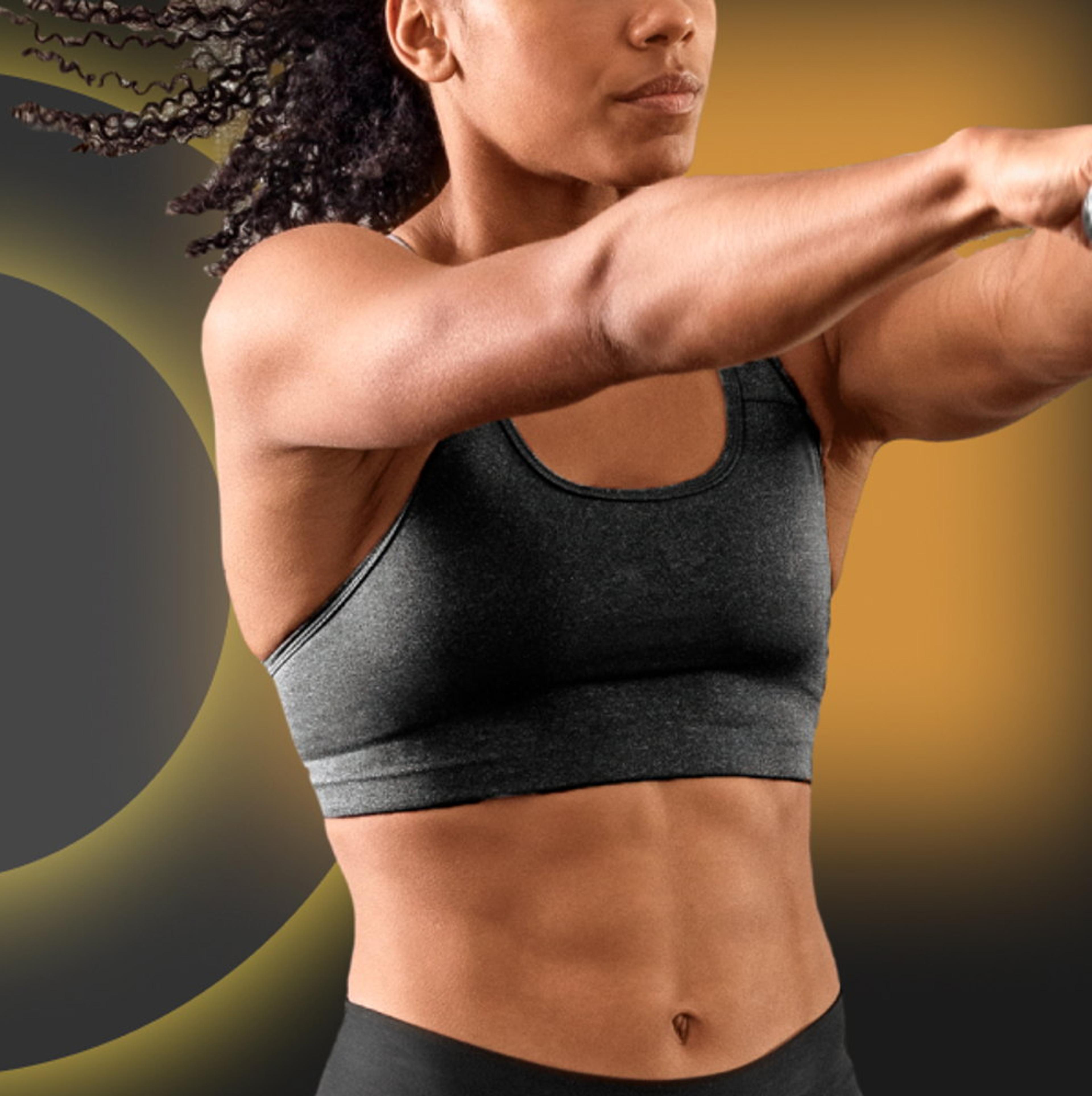 Eine athletische Frau in einem grauen Sport-BH, die eine Trainingsübung ausführt