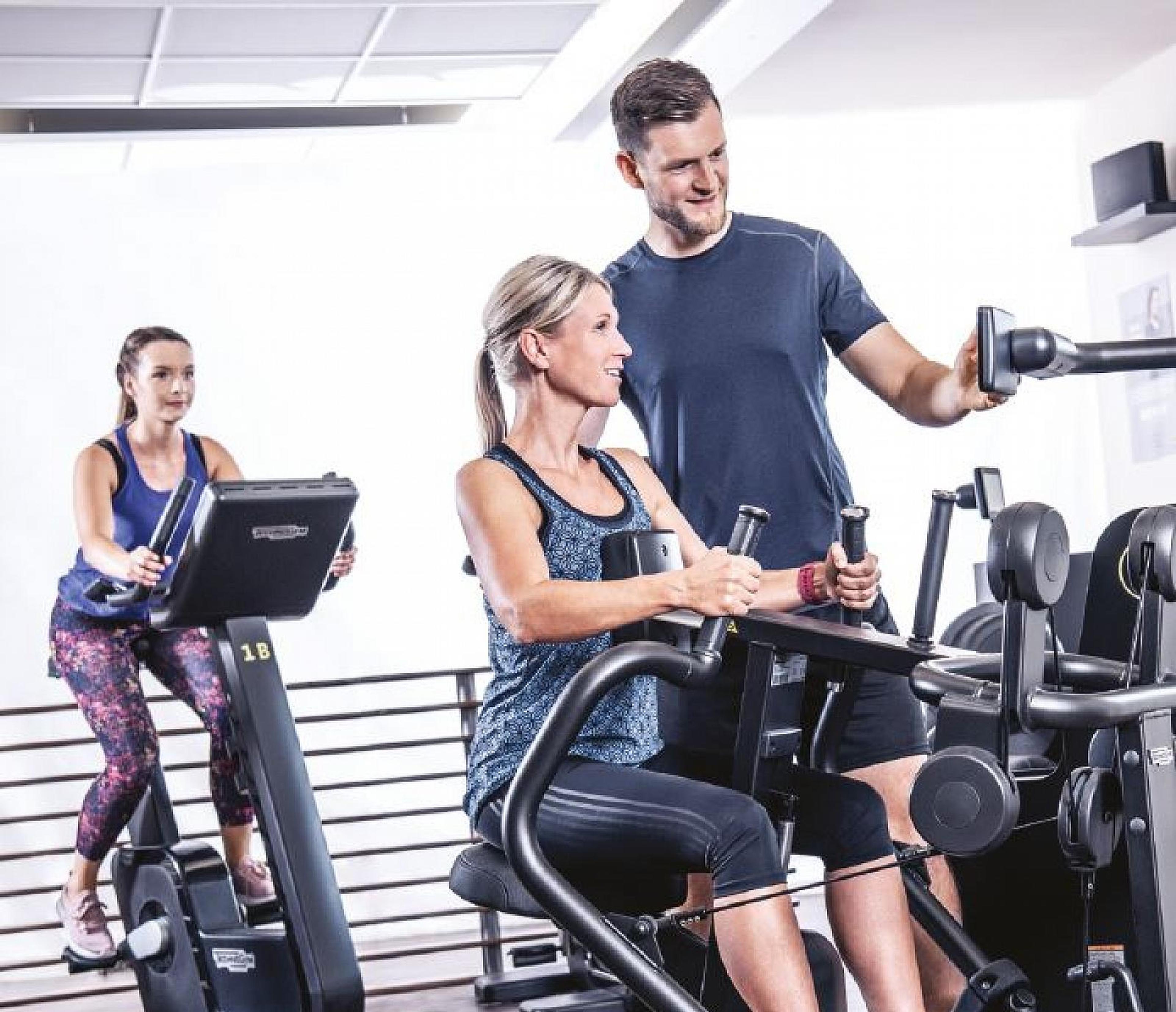 Eine sportliche Frau in orangefarbener Leggings und weißem Top macht Bauchmuskelübungen auf einer Yogamatte
