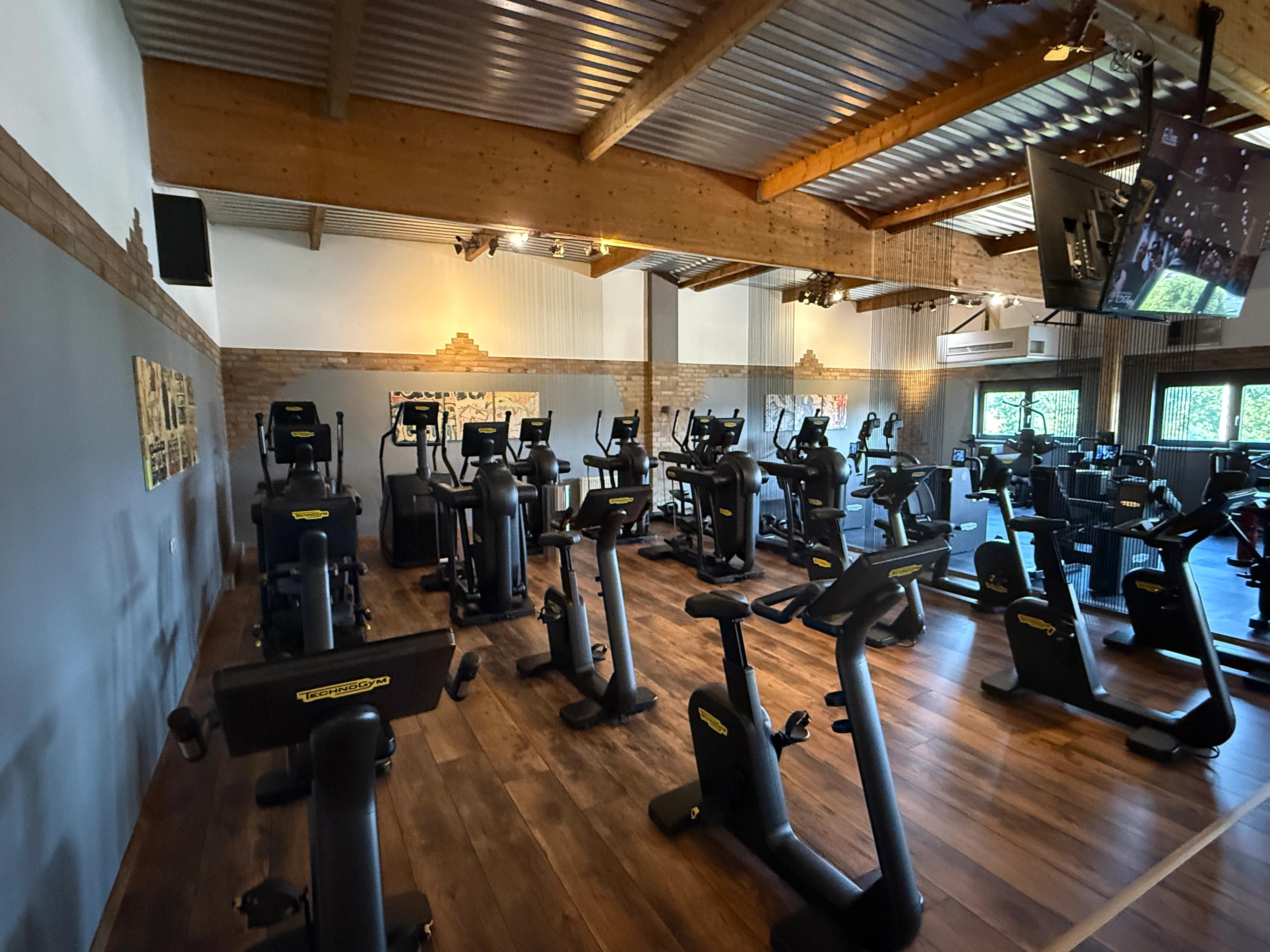 Ein modernes Fitnessstudio mit verschiedenen Kraftgeräten und einem offenen Trainingsbereich